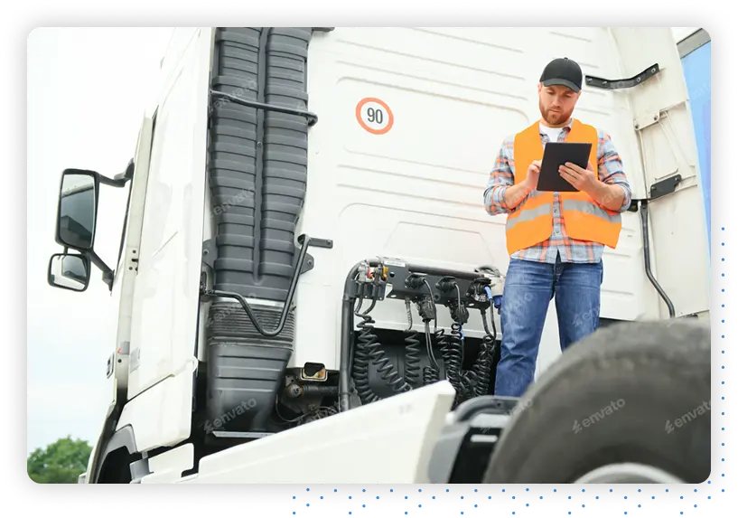 Man standing on a truck looking at a tablet
